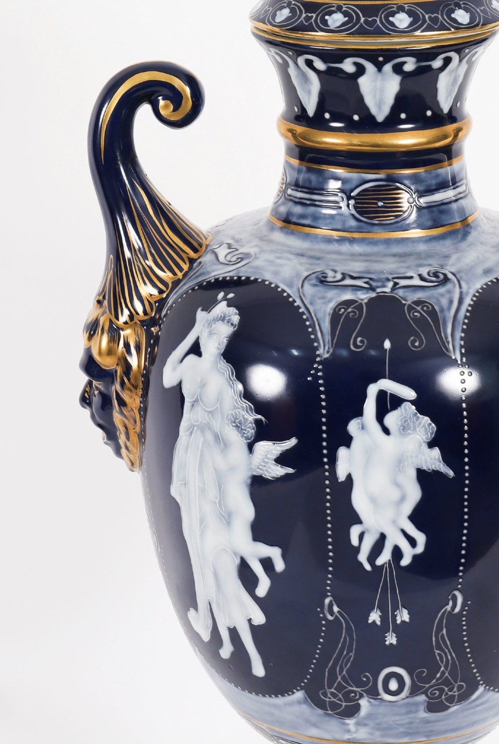 A pair of cobalt blue and white porcelain lidded vases featuring classical figures, scrolling handles, and gilded finials. View VII