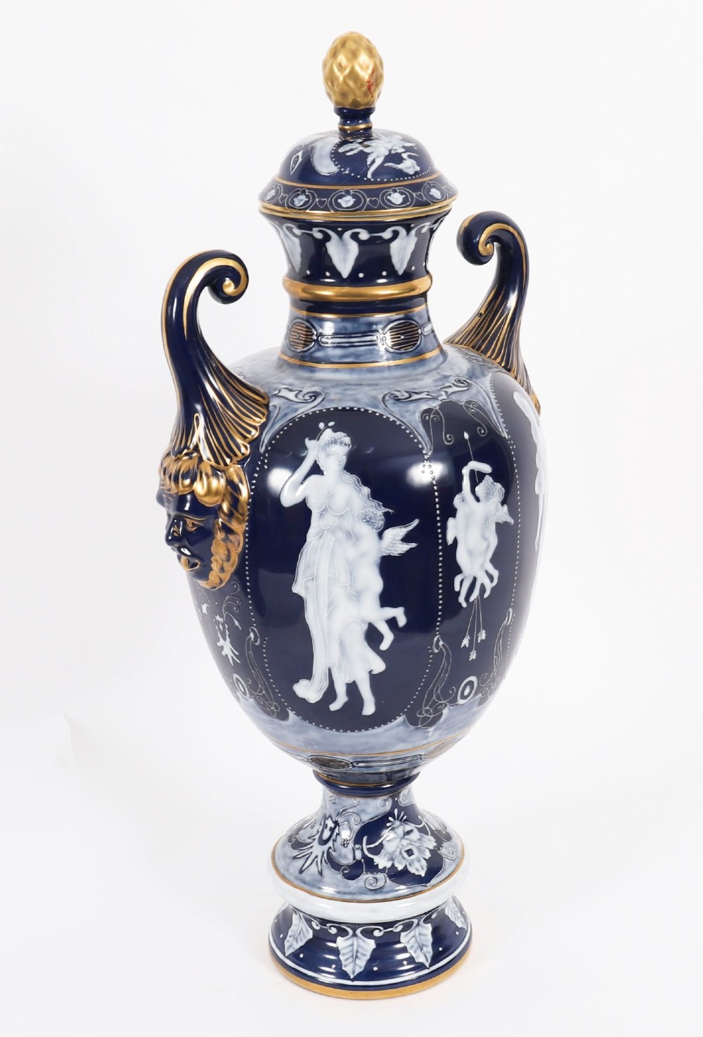 A pair of cobalt blue and white porcelain lidded vases featuring classical figures, scrolling handles, and gilded finials. View VIII