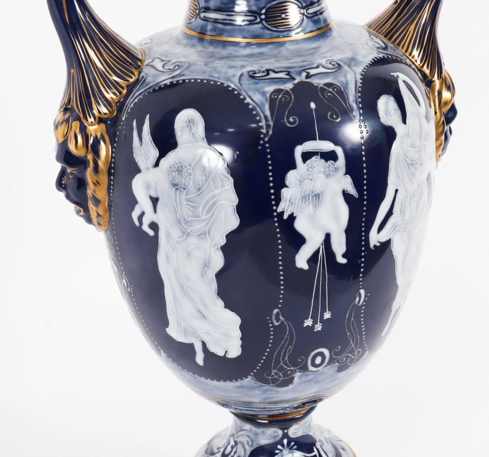 A pair of cobalt blue and white porcelain lidded vases featuring classical figures, scrolling handles, and gilded finials. View XII