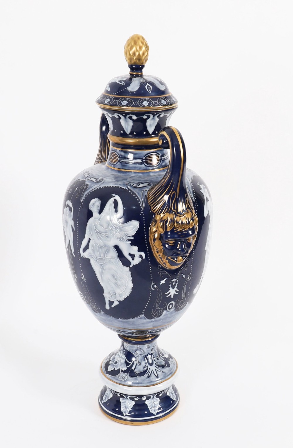 A pair of cobalt blue and white porcelain lidded vases featuring classical figures, scrolling handles, and gilded finials. View XV