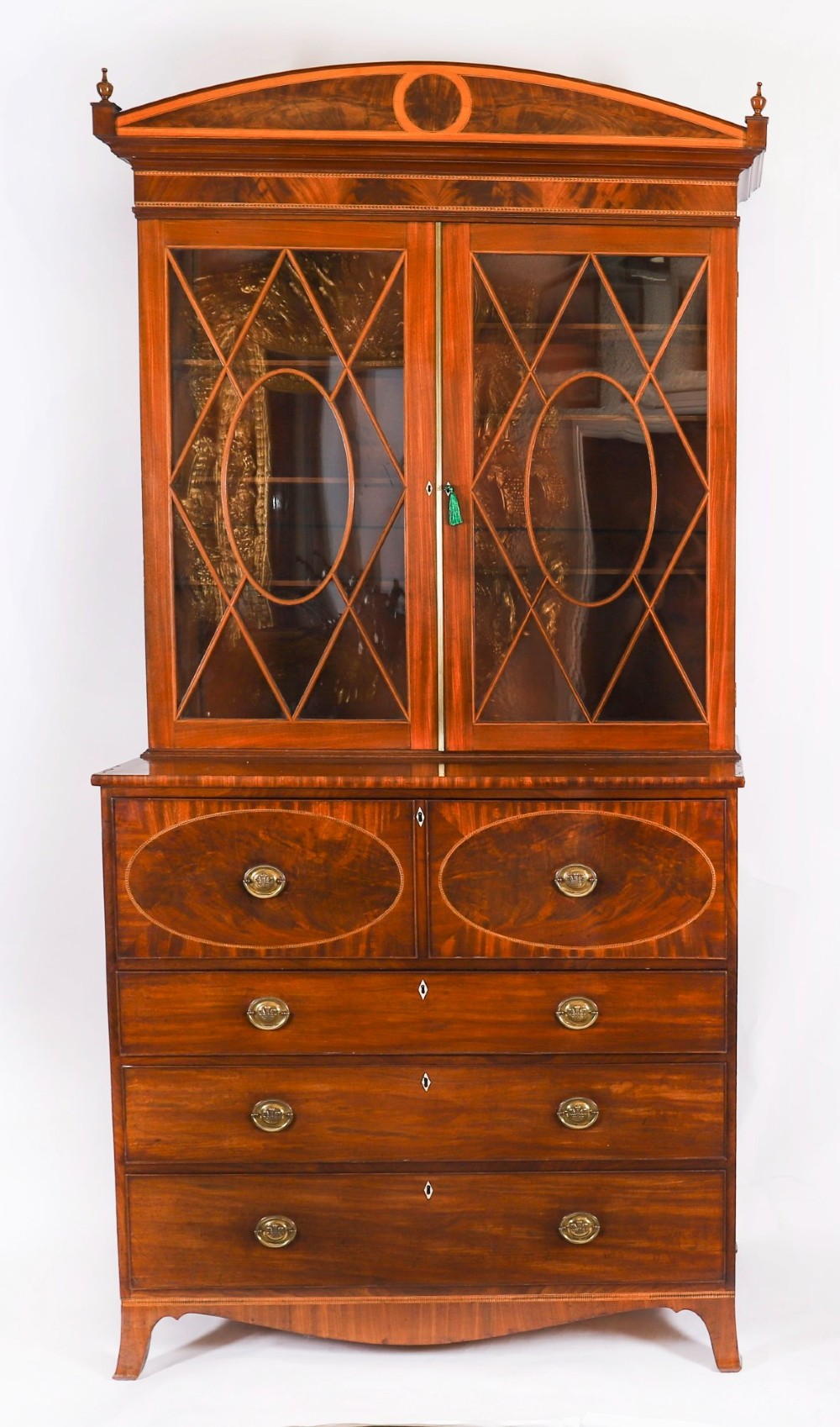 An antique George III flame mahogany secretaire bookcase featuring a shaped pediment, two upper astragal glazed doors, and a lower four-drawer chest base with brass ring handles. View II