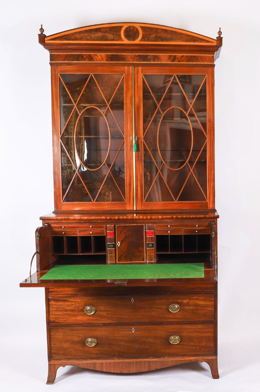 An antique George III flame mahogany secretaire bookcase featuring a shaped pediment, two upper astragal glazed doors, and a lower four-drawer chest base with brass ring handles. View III