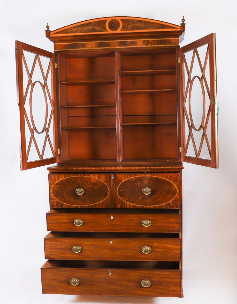 An antique George III flame mahogany secretaire bookcase featuring a shaped pediment, two upper astragal glazed doors, and a lower four-drawer chest base with brass ring handles. View XI
