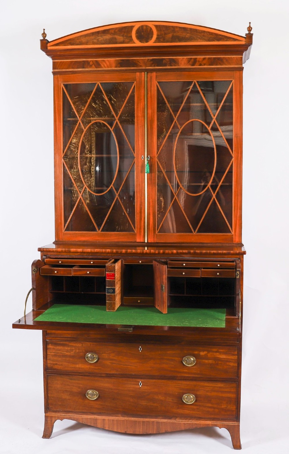 An antique George III flame mahogany secretaire bookcase featuring a shaped pediment, two upper astragal glazed doors, and a lower four-drawer chest base with brass ring handles. View XII