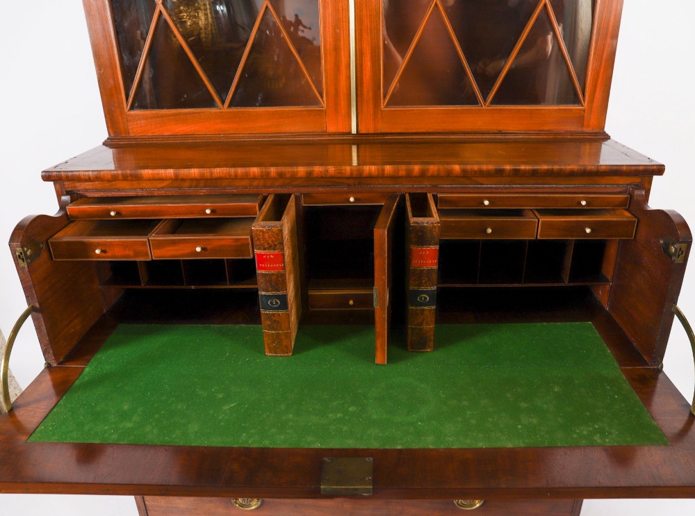 An antique George III flame mahogany secretaire bookcase featuring a shaped pediment, two upper astragal glazed doors, and a lower four-drawer chest base with brass ring handles. View XIII