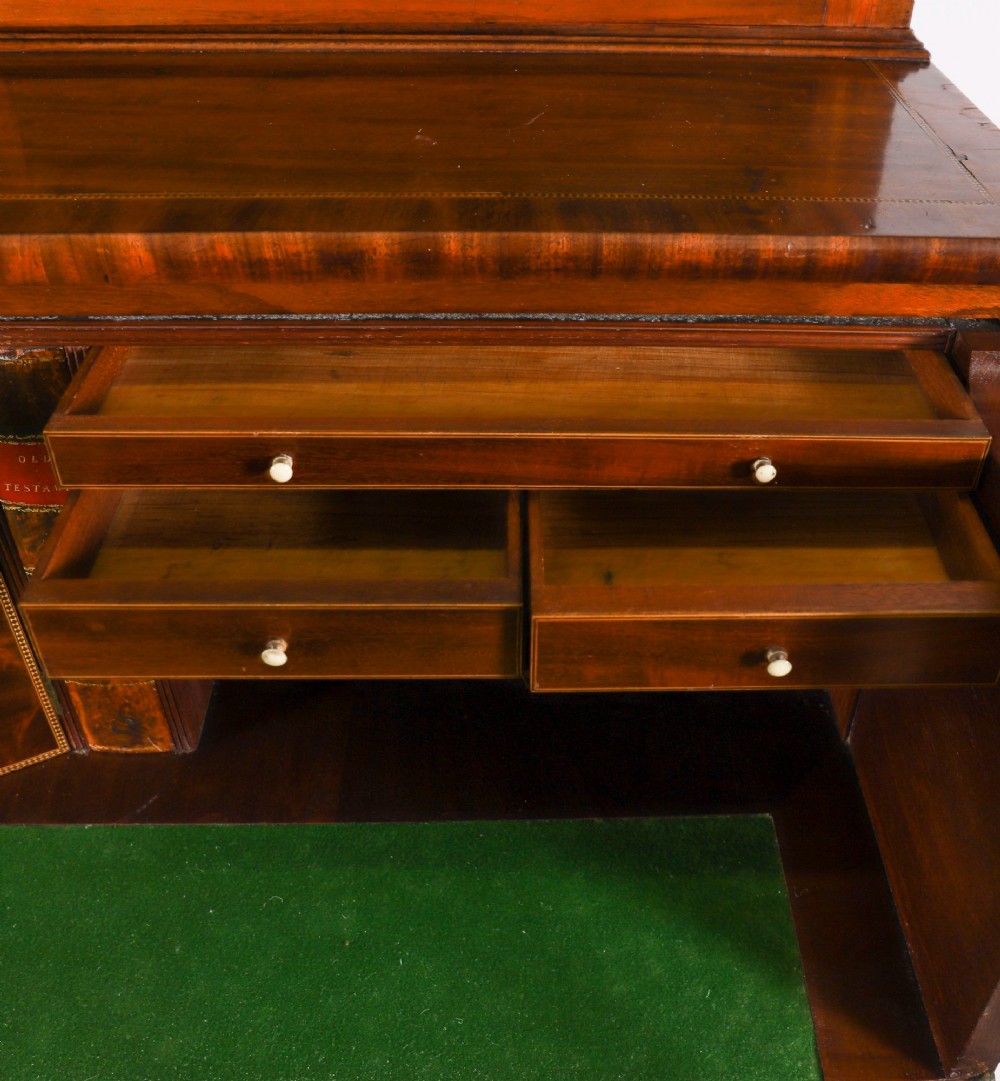 An antique George III flame mahogany secretaire bookcase featuring a shaped pediment, two upper astragal glazed doors, and a lower four-drawer chest base with brass ring handles. View XIV
