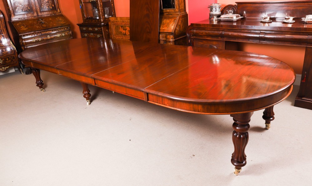 A large George III extending dining table in Cuban flame mahogany with turned fluted legs and brass castors. View VI