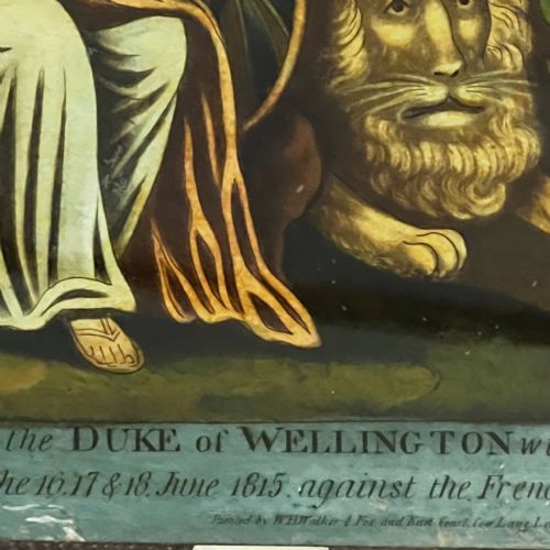 fig 2. A framed 19th-century reverse glass print depicting Britannia crowning the Duke of Wellington alongside a lion and military motifs in a dark wooden frame.