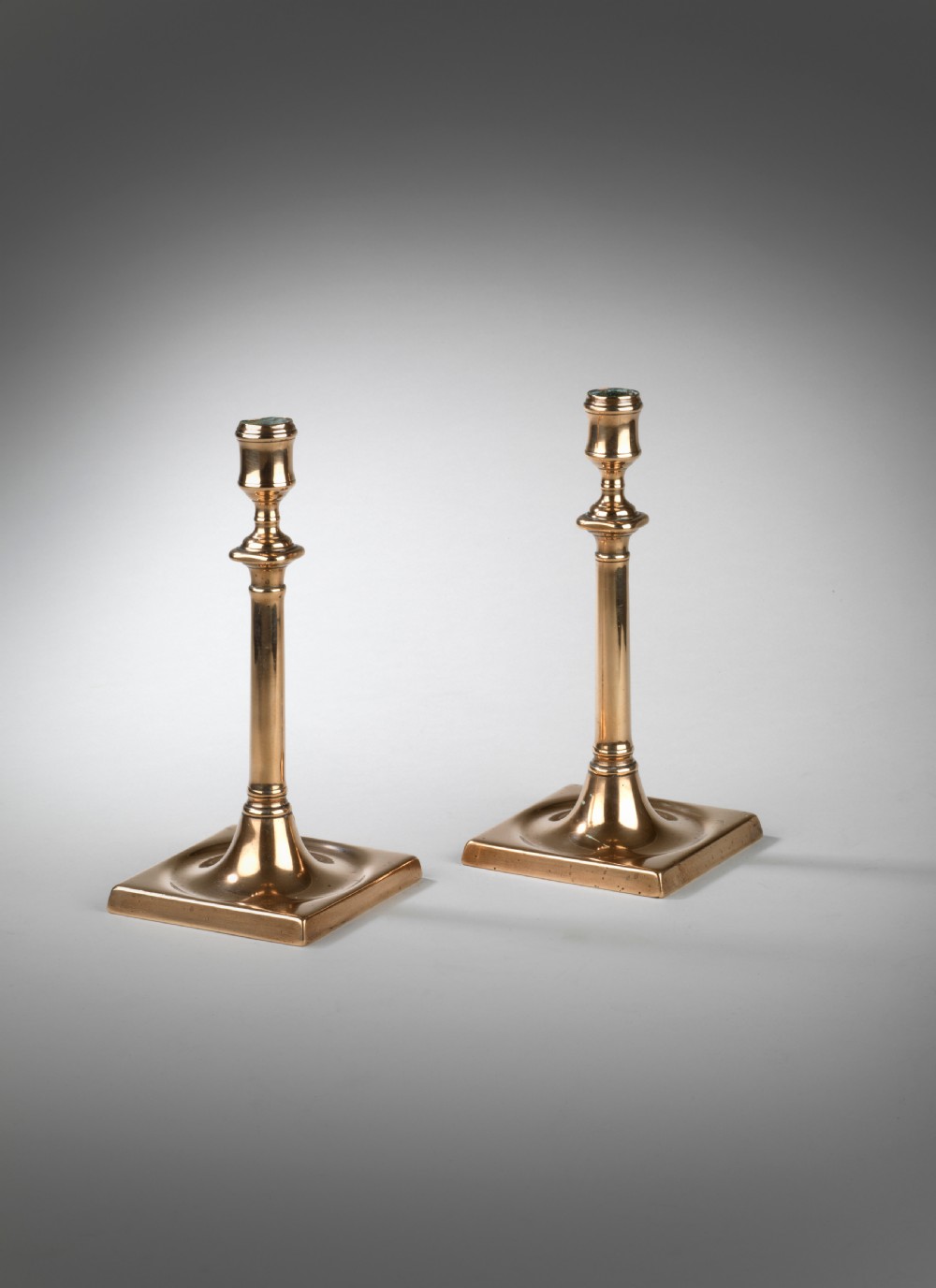 Pair of Georgian square base brass candlesticks