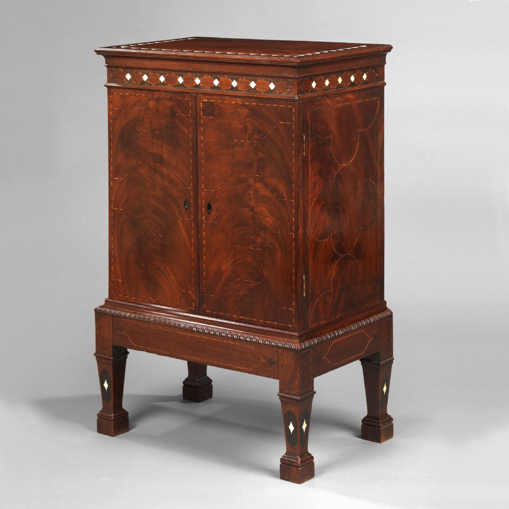 A mid-18th century Chippendale mahogany collectors cabinet on stand featuring diamond bone inlays, delicate line decoration, and two panelled doors.