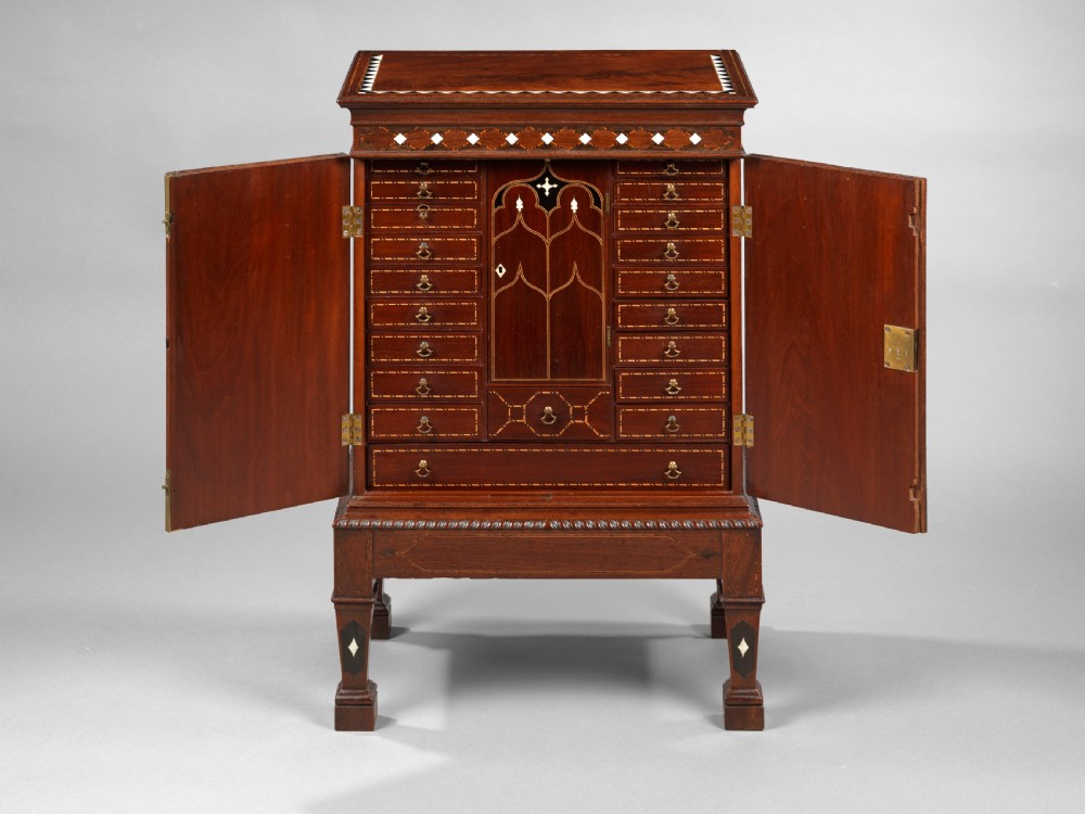 A mid-18th century Chippendale mahogany collectors cabinet on stand featuring diamond bone inlays, delicate line decoration, and two panelled doors. View V