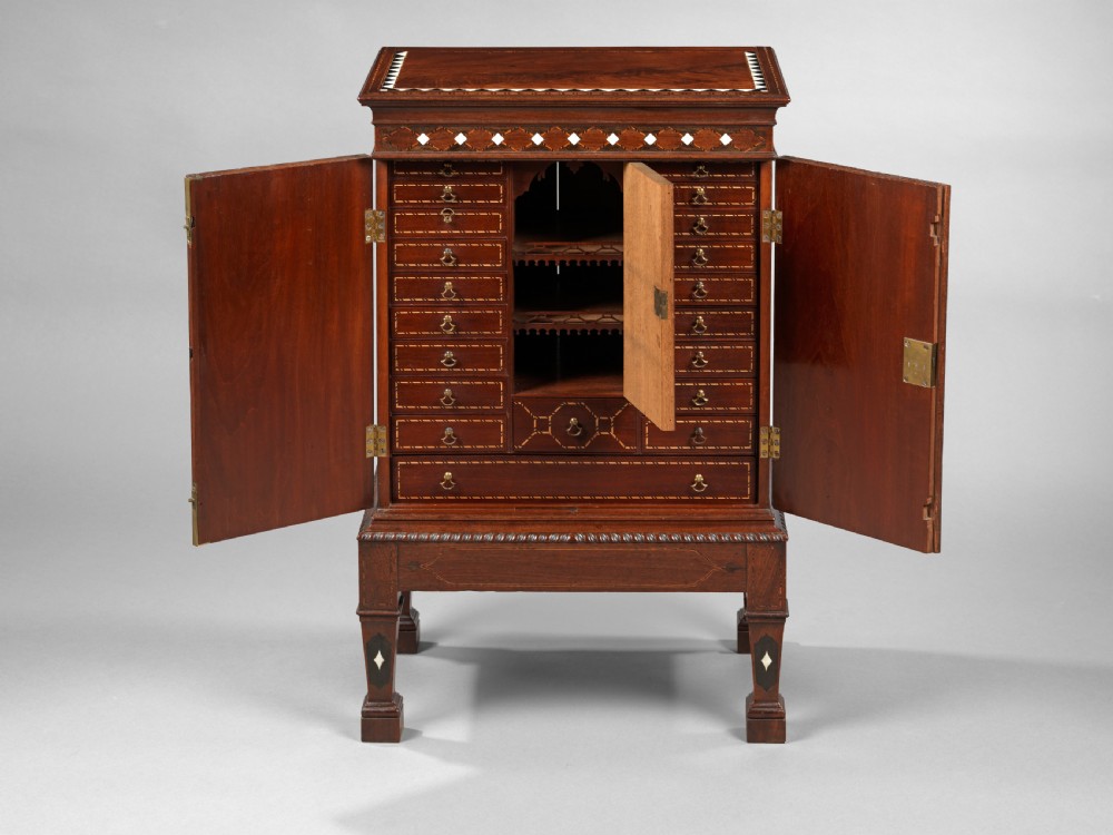 A mid-18th century Chippendale mahogany collectors cabinet on stand featuring diamond bone inlays, delicate line decoration, and two panelled doors. View VII
