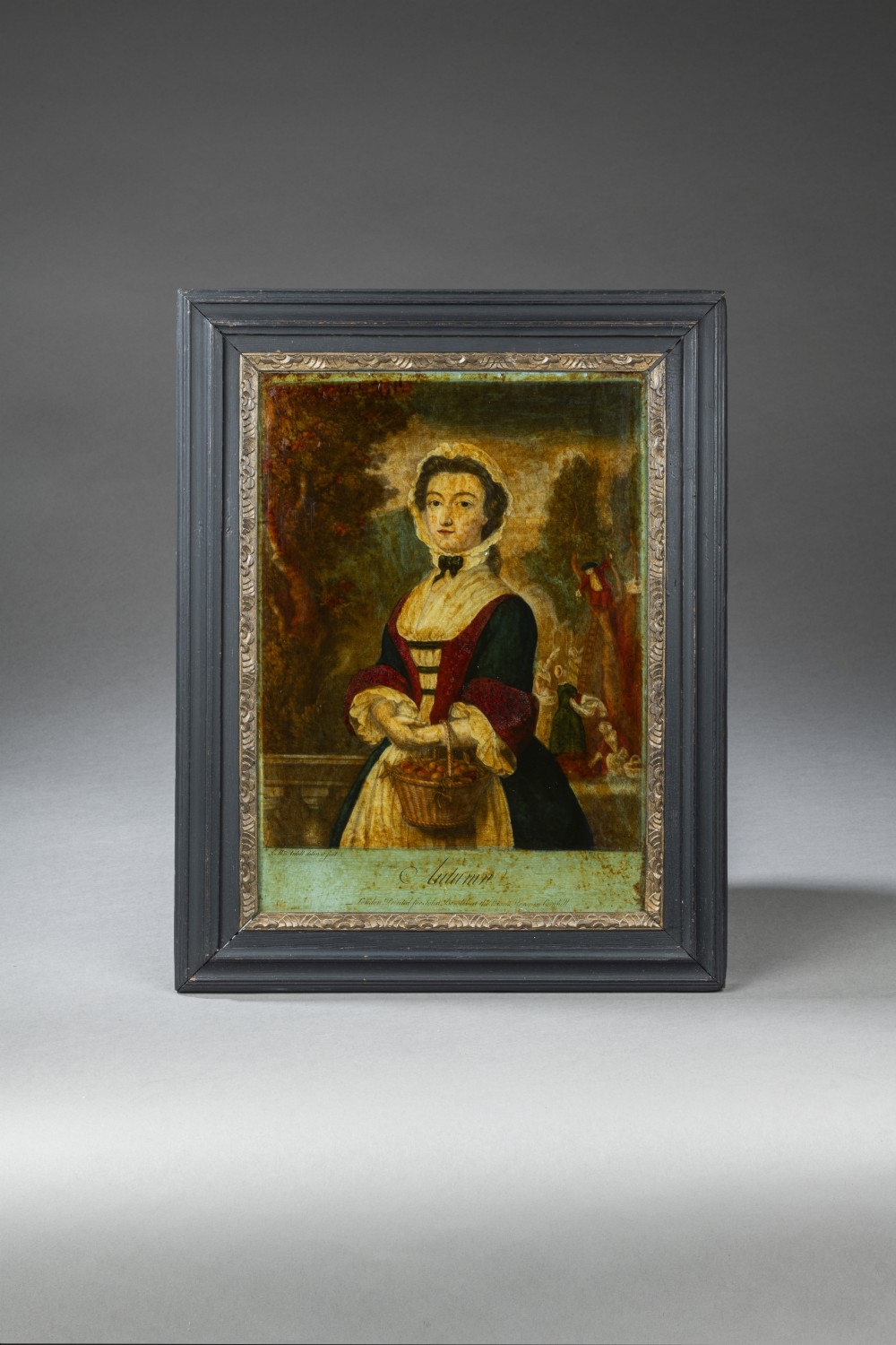 A Georgian reverse glass print depicting an allegorical figure representing Autumn holding a basket of fruit within a dark wood and gilt frame.
