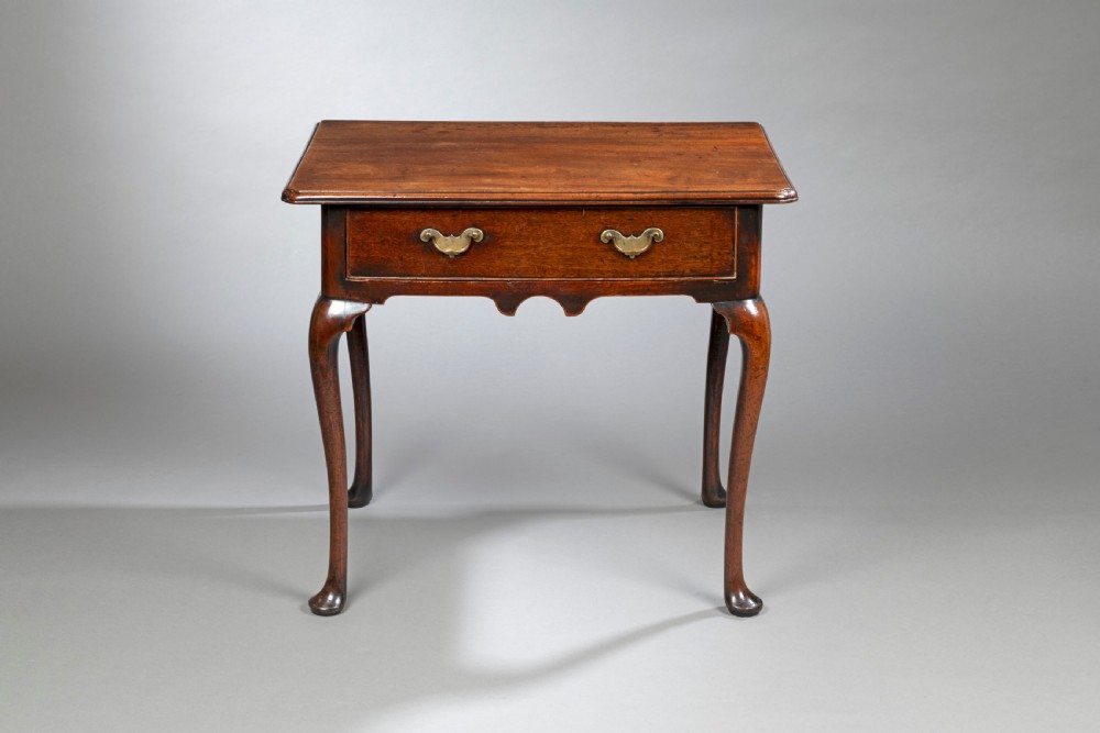 A George II mahogany side table with cabriole legs, pad feet, a moulded top, and a single frieze drawer fitted with brass handles. View II