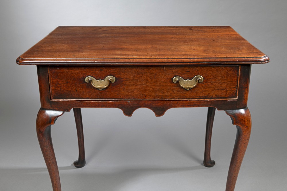 A George II mahogany side table with cabriole legs, pad feet, a moulded top, and a single frieze drawer fitted with brass handles. View III