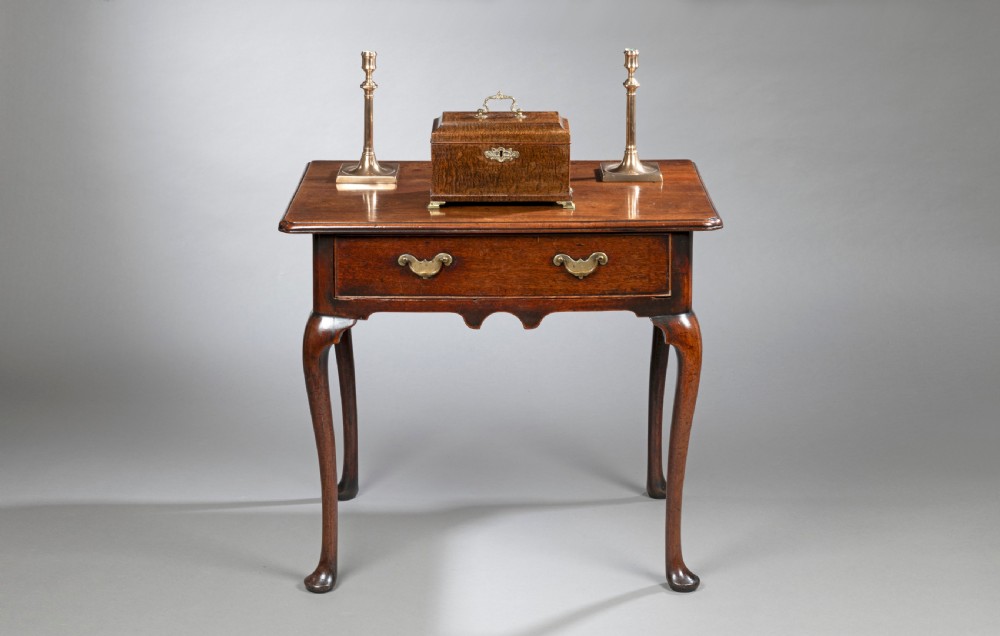 A George II mahogany side table with cabriole legs, pad feet, a moulded top, and a single frieze drawer fitted with brass handles. View V