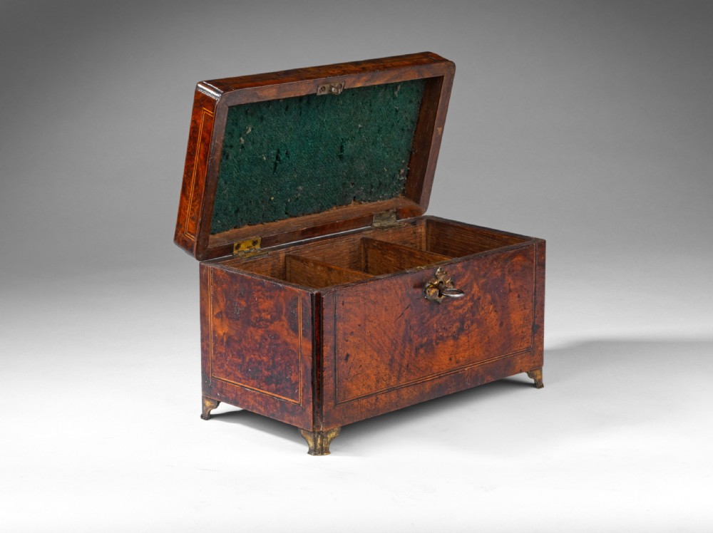 A rectangular George II burr walnut tea caddy with a top brass carrying handle, crossbanded inlay borders, and a decorative brass escutcheon with key. View III