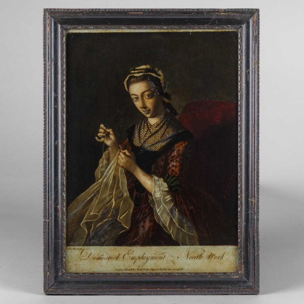 A framed Georgian reverse glass print depicting a woman engaged in needlework, housed in a dark moulded wooden frame with text along the lower edge.