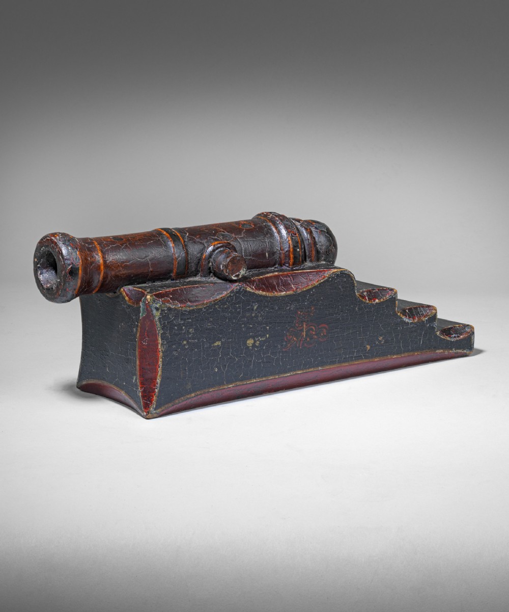 An early nineteenth-century bronze signal cannon barrel mounted on a dark painted stepped wooden carriage.