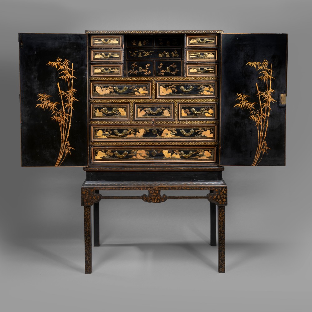 A 19th-century Chinese black lacquer cabinet decorated with intricate gilt landscapes, mounted on a matching tall table stand. View IV