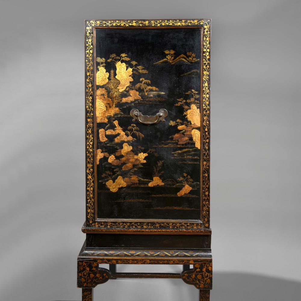 A 19th-century Chinese black lacquer cabinet decorated with intricate gilt landscapes, mounted on a matching tall table stand. View V