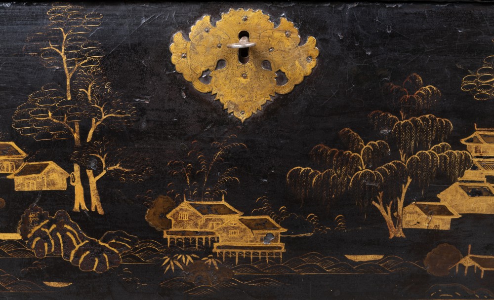 An eighteenth-century black lacquer coffer featuring gold chinoiserie landscape paintings, resting on a matching wooden stand. View II