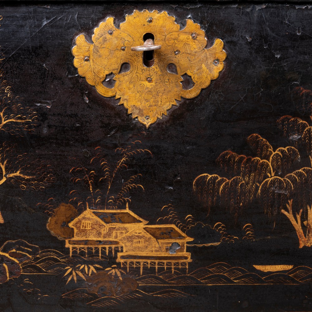 An eighteenth-century black lacquer coffer featuring gold chinoiserie landscape paintings, resting on a matching wooden stand. View III