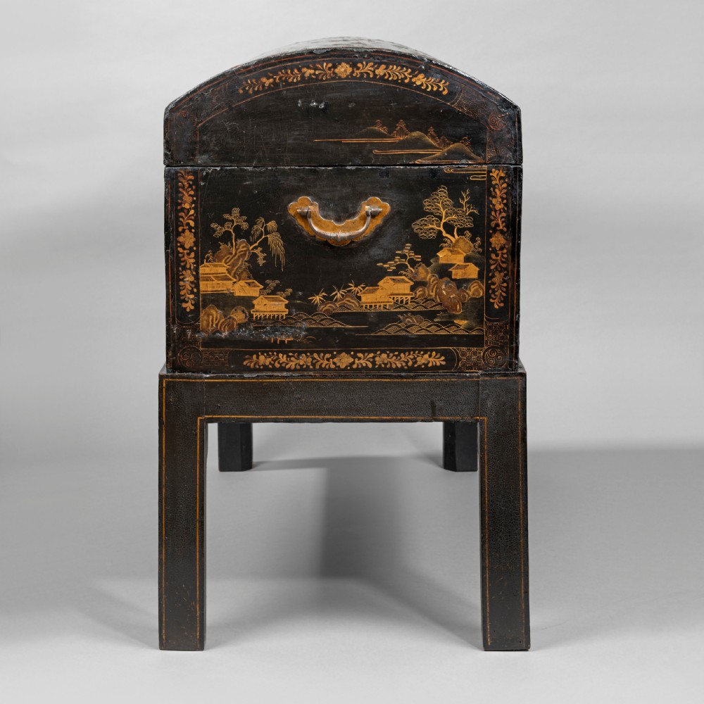 An eighteenth-century black lacquer coffer featuring gold chinoiserie landscape paintings, resting on a matching wooden stand. View V