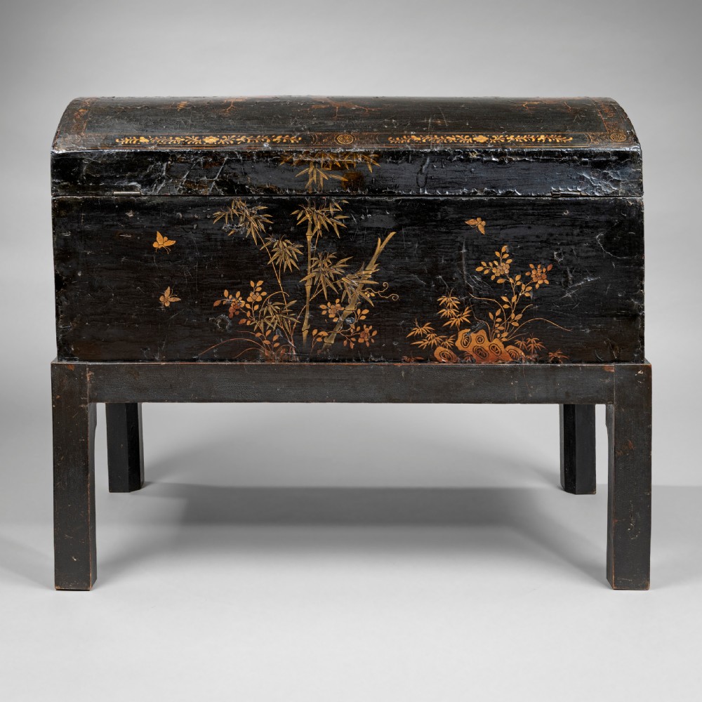An eighteenth-century black lacquer coffer featuring gold chinoiserie landscape paintings, resting on a matching wooden stand. View VII