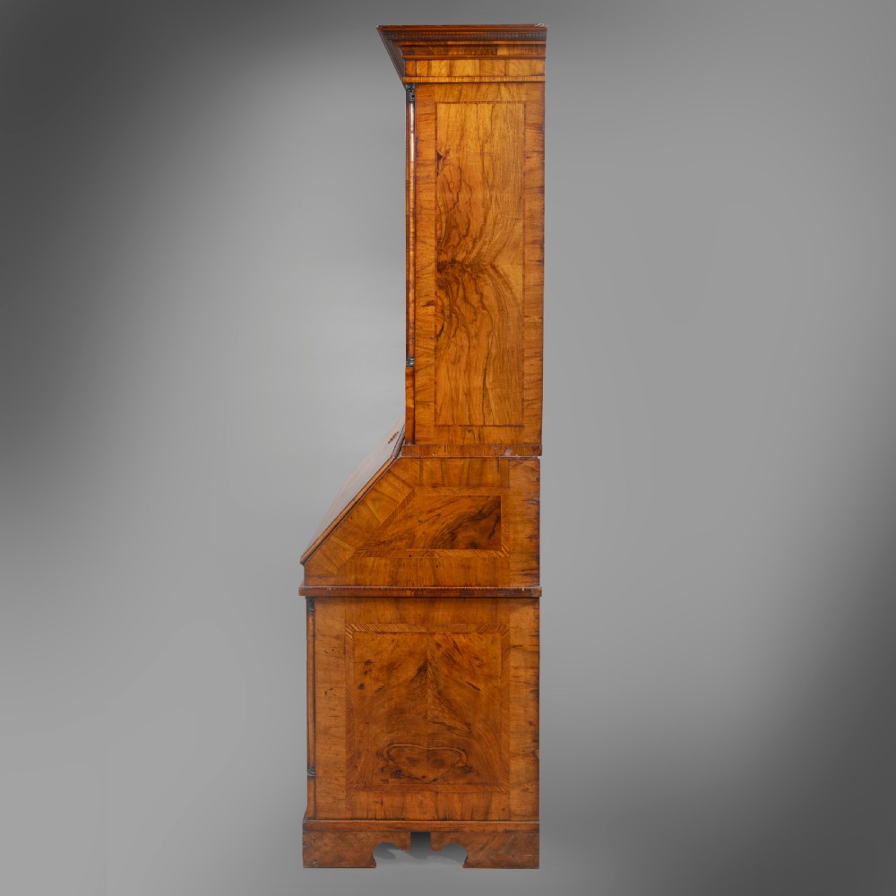 An eighteenth-century walnut bureau bookcase with double panelled doors above a sloping slant-front writing surface and drawers. View II