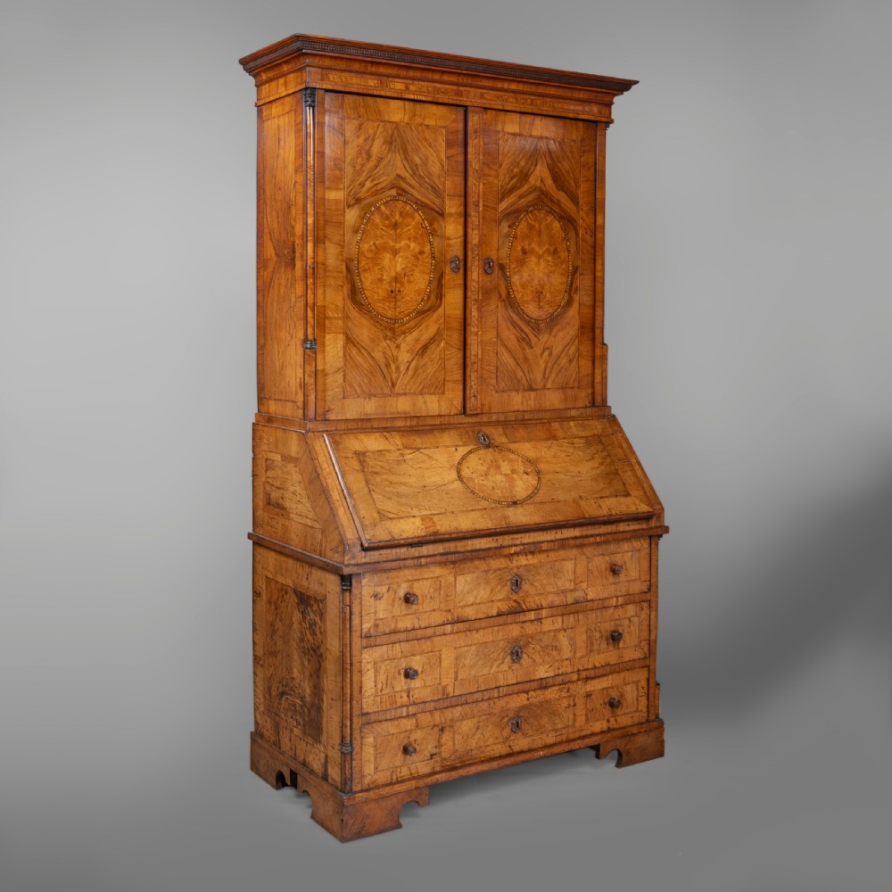 An eighteenth-century walnut bureau bookcase with double panelled doors above a sloping slant-front writing surface and drawers. View III