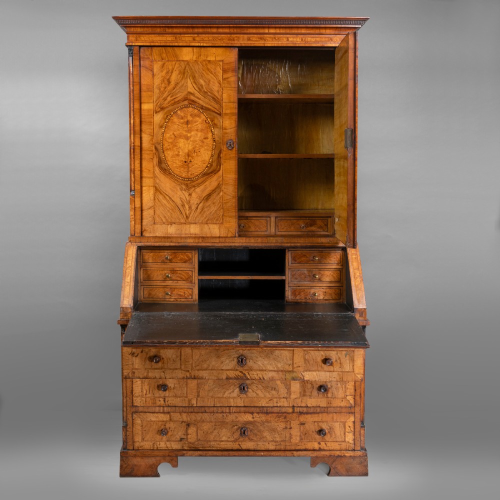 An eighteenth-century walnut bureau bookcase with double panelled doors above a sloping slant-front writing surface and drawers. View V