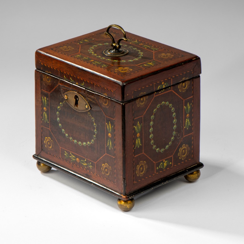 A square dark warm brown mahogany tea caddy featuring hand-painted floral motifs, a brass keyhole escutcheon, a brass top handle, and four small ball feet. View III