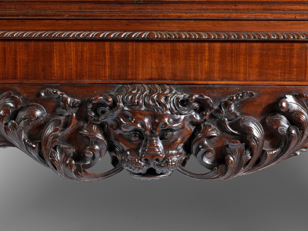 A dark mahogany George II style display cabinet on stand featuring glazed double doors, a carved apron with central mask detail, and cabriole legs with claw and ball feet. View III