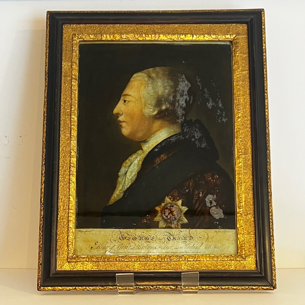 An 18th-century reverse glass portrait of King George III in profile, set within an ebonised and gilt moulded frame.