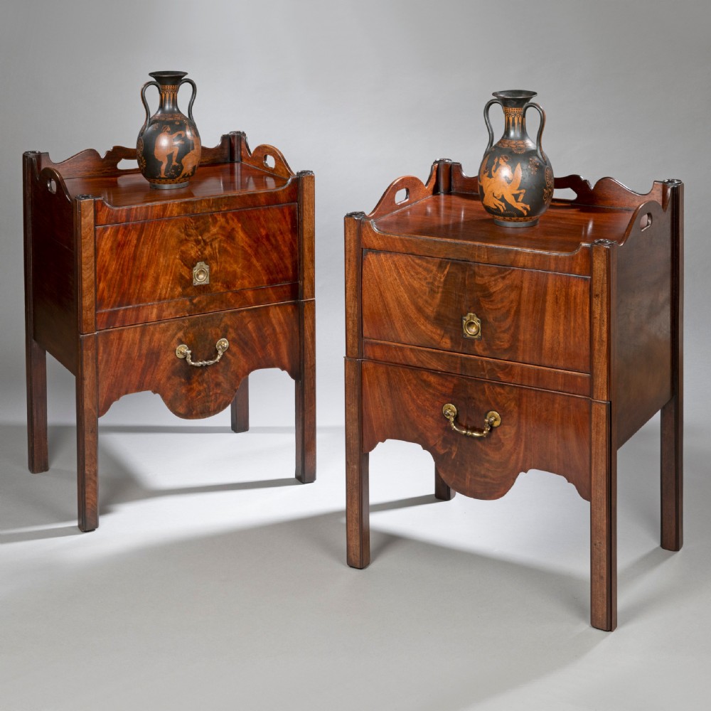 A pair of Georgian Chippendale mahogany tray top commodes featuring pierced side handles, galleried rims, flame mahogany fronts, and brass handles on square legs. View II