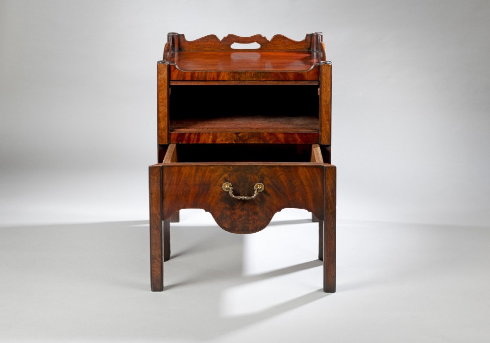 A pair of Georgian Chippendale mahogany tray top commodes featuring pierced side handles, galleried rims, flame mahogany fronts, and brass handles on square legs. View III