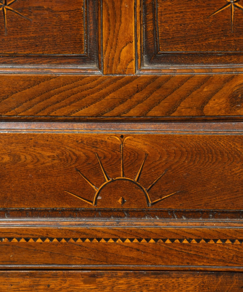 An 18th-century Georgian dark oak corner cupboard featuring a swan-neck pediment, glazed upper door panels, and decorative inlay motifs. View II