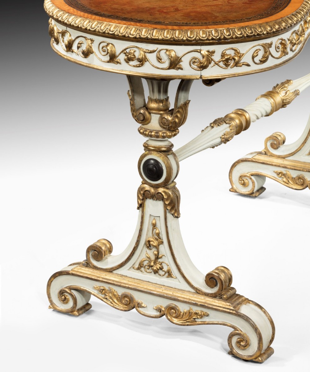 A kidney-shaped William IV writing table featuring an ivory-painted finish, detailed carved giltwood embellishments, a turned stretcher, and a brown leather inset surface. View V
