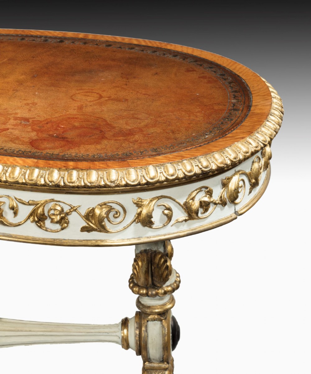 A kidney-shaped William IV writing table featuring an ivory-painted finish, detailed carved giltwood embellishments, a turned stretcher, and a brown leather inset surface. View VI
