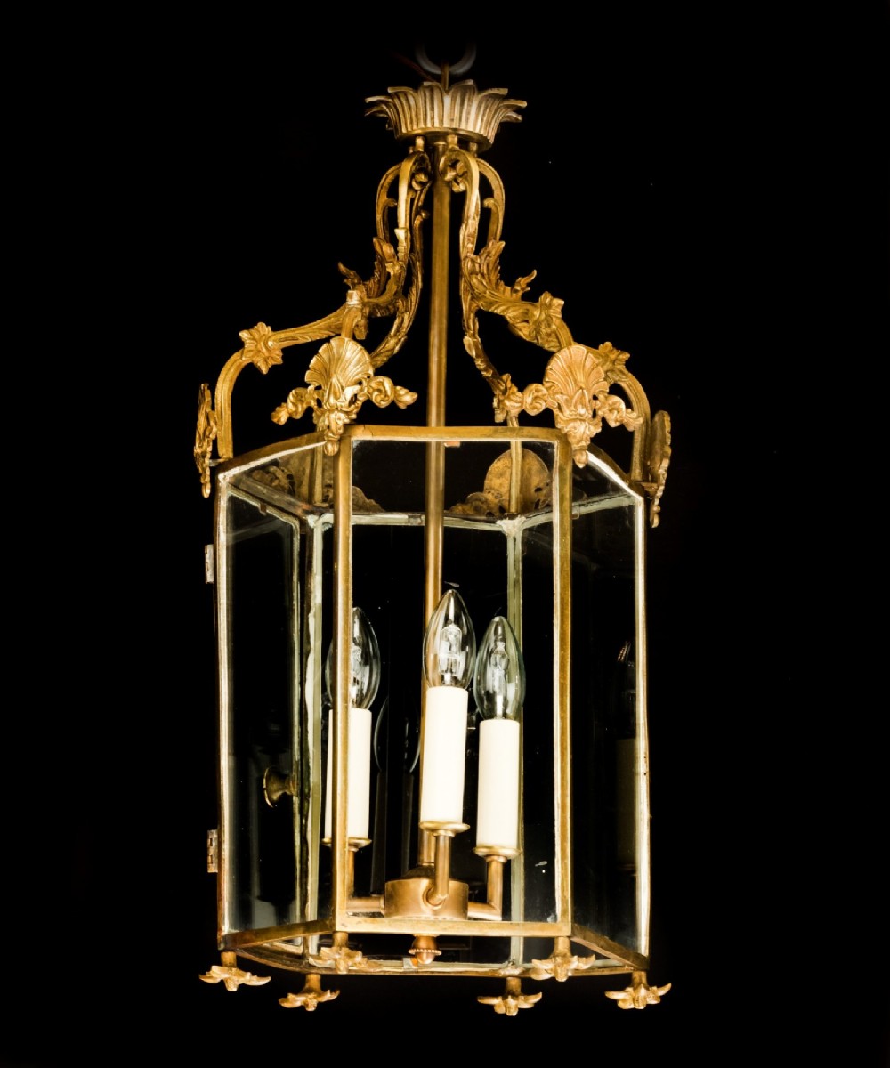 An antique Neo-Classical brass hanging hall lantern featuring glazed glass panels and three internal candle-style lights. View III