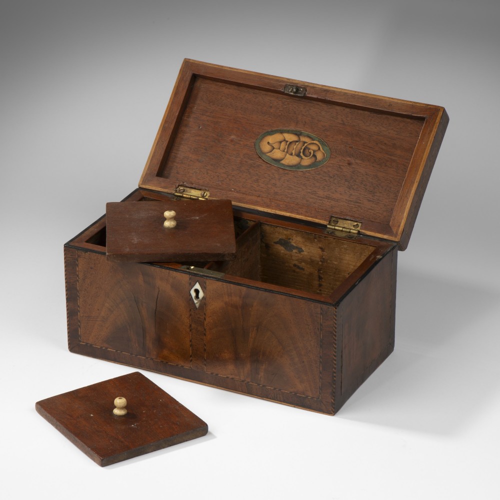 A rectangular Georgian mahogany tea caddy featuring decorative geometric stringing inlay along the edges and a diamond-shaped white keyhole escutcheon on the front. View II