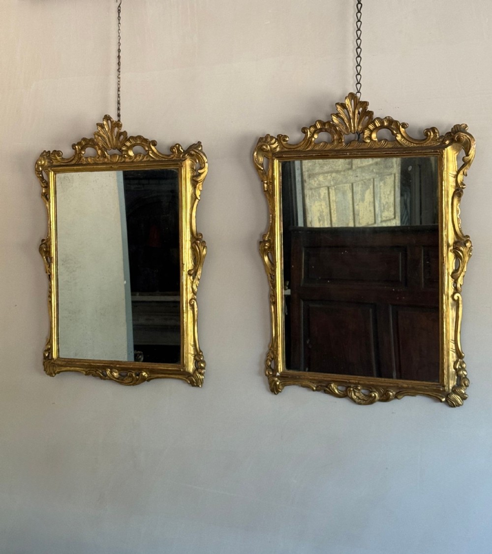 A symmetrical pair of rectangular wall mirrors framed in carved gold giltwood with acanthus leaf cresting and rococo scroll details. View III