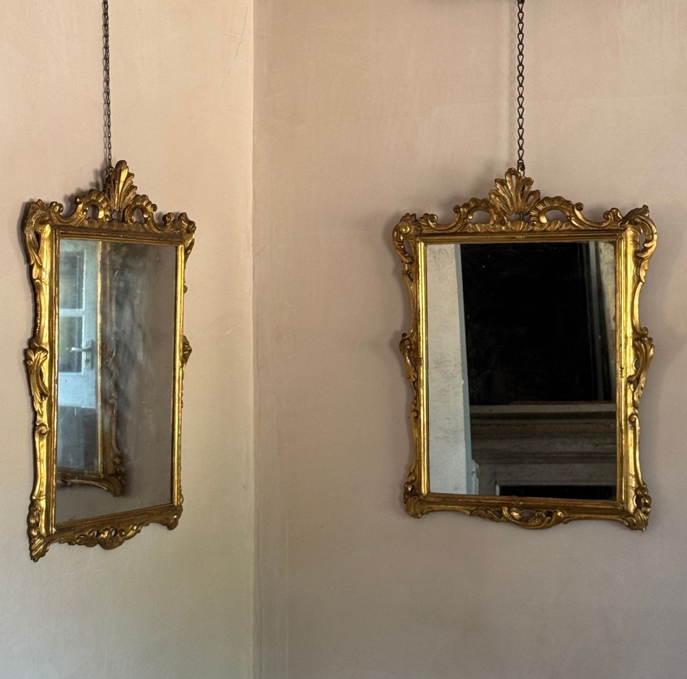 A symmetrical pair of rectangular wall mirrors framed in carved gold giltwood with acanthus leaf cresting and rococo scroll details. View IV