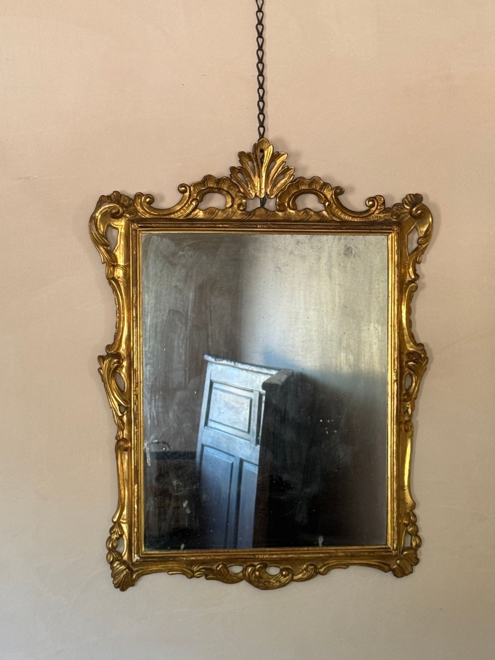 A symmetrical pair of rectangular wall mirrors framed in carved gold giltwood with acanthus leaf cresting and rococo scroll details. View V