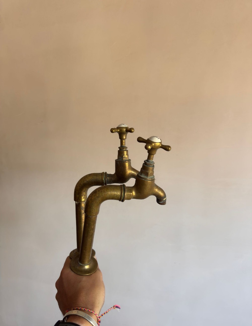 A pair of reclaimed antique brass bib taps with crosshead handles mounted on extended brass standpipes. View VI
