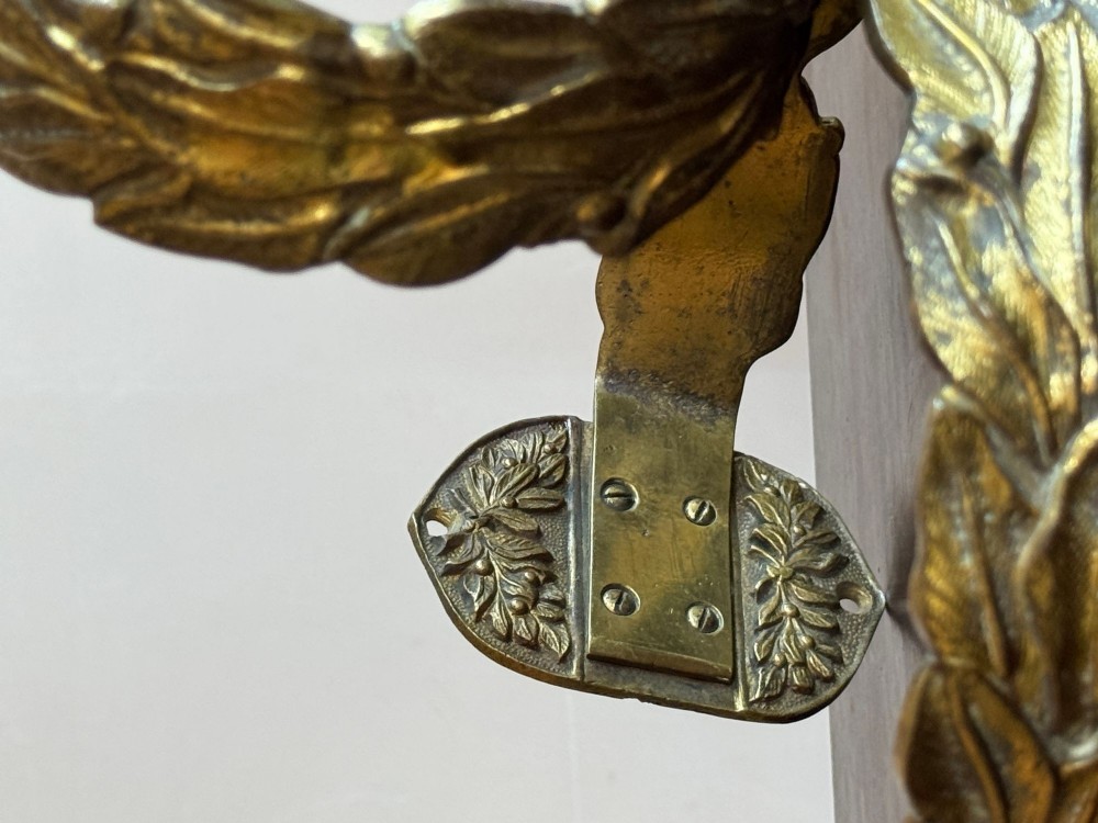A pair of 19th-century gilt brass curtain tie-backs featuring cast foliage motifs and round mounting plates. View III