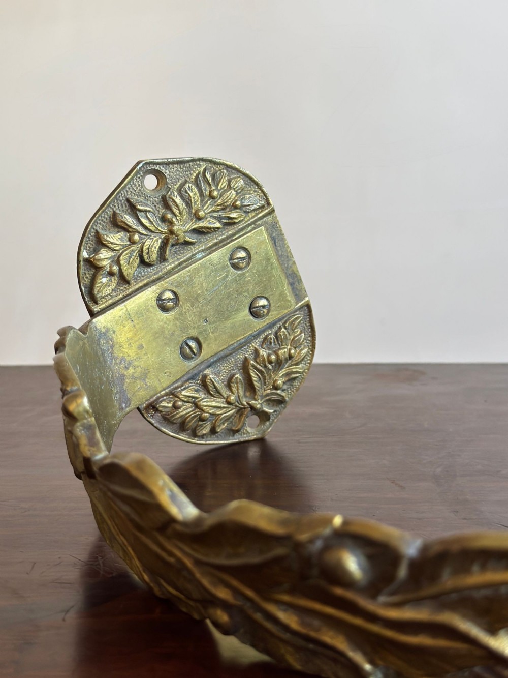 A pair of 19th-century gilt brass curtain tie-backs featuring cast foliage motifs and round mounting plates. View VIII