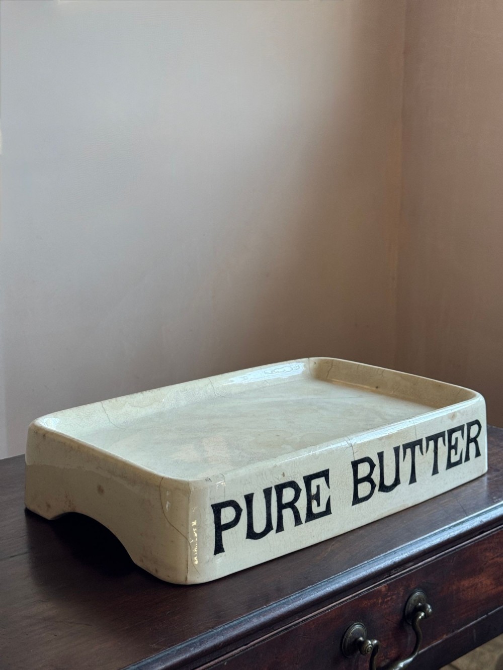 A rectangular cream ceramic grocers slab with black transfer-printed typography reading PURE BUTTER on the front edge. View IV