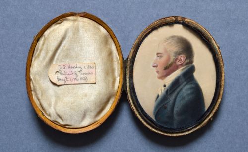 fig 1. An oval watercolour portrait miniature showing a profile view of a gentleman wearing a dark blue coat and white cravat set in a leather case.